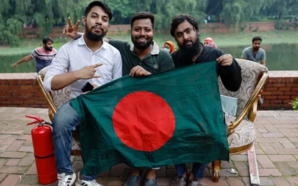 Des manifestants posent avec le drapeau du Bangladesh sur un canapé pillé dans la résidence de la Première ministre. Photo: REUTERS